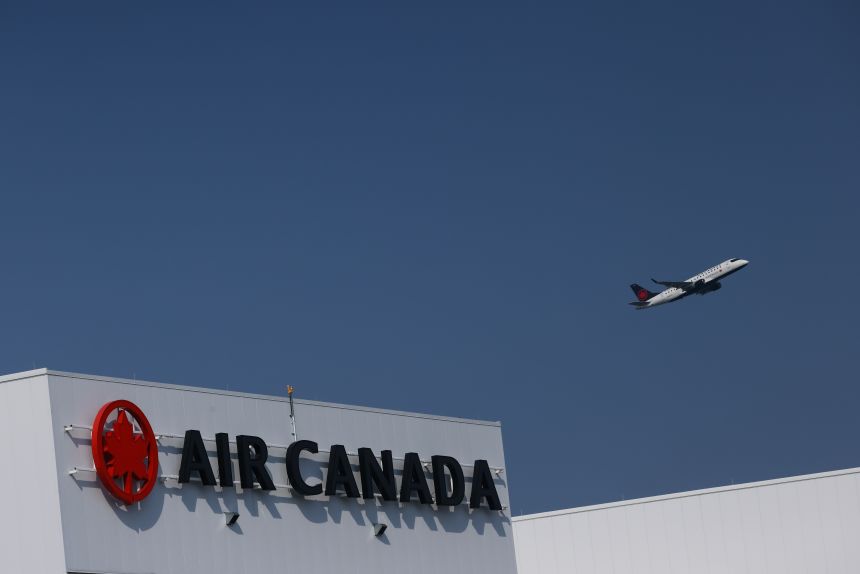 An Air Canada plane takes off behind an Air Canada logo at Pearson International Airport in Toronto on August 14, 2025
