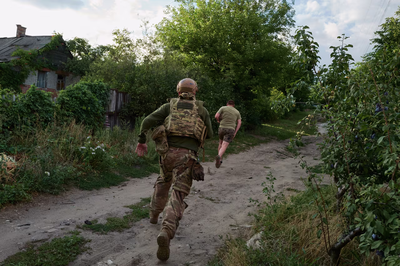 Ukrainian servicemen run for cover following a Russian airstrike in Sloviansk, Ukraine, on Thursday.