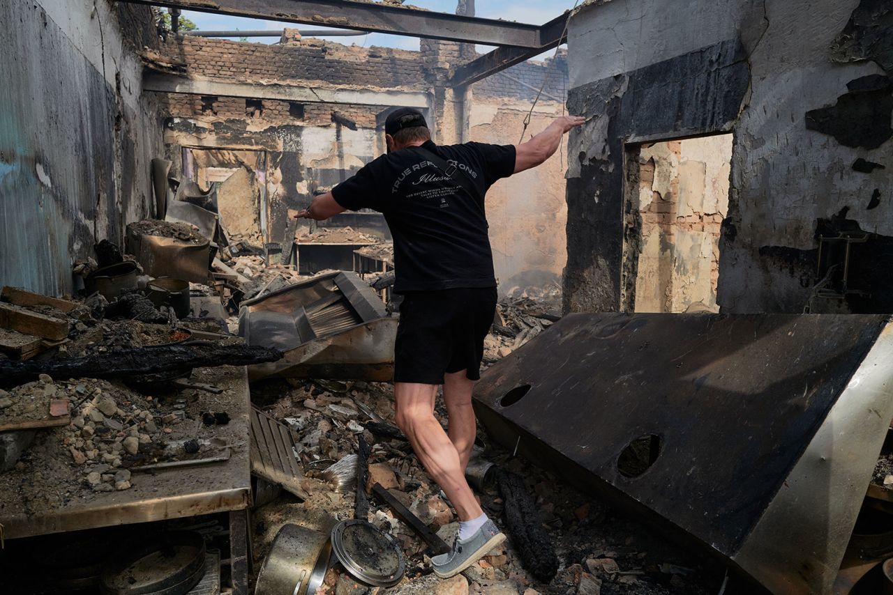 A restaurant owner walks through the smoldering rubble of his establishment, destroyed overnight by Russian forces on Thursday,  in Bilozerske, Ukraine, located on the frontline near Dobropillia.