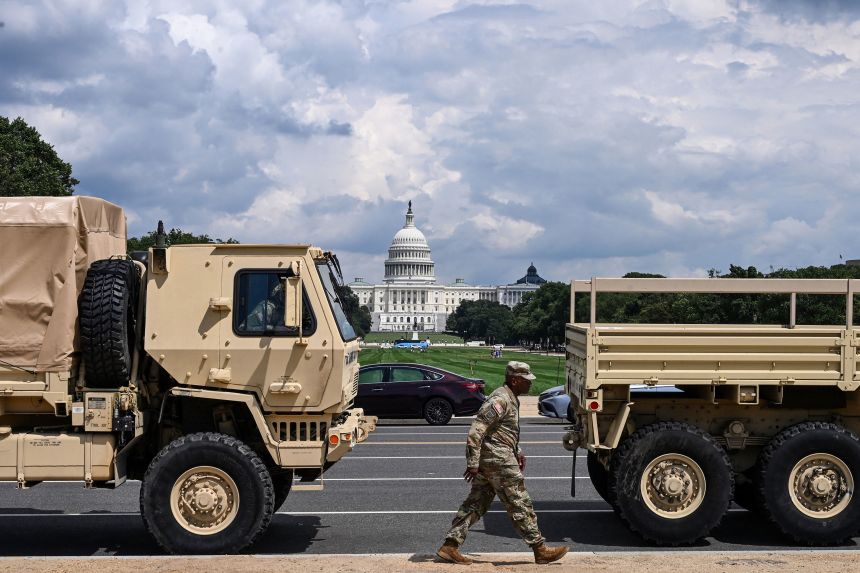 A member of the US National Guard walks past military vehicles on the National Mall in Washington, DC, on August 14.