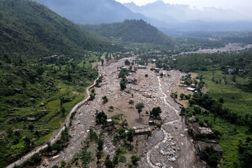 An aerial view shows houses partially submerged in sludge along a riverbed in the aftermath of flash floods at the Buner district of Khyber Pakhtunkhwa province, on August 17, 2025.