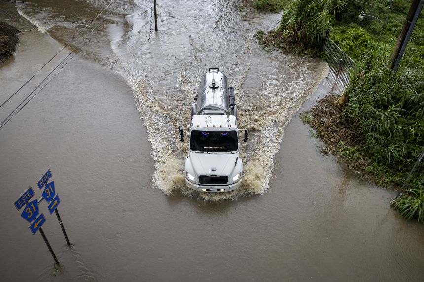 A truck drives through a flooded road as Category 3 Hurricane Erin leaves the region in Naguabo, Puerto Rico, on August 16, 2025.