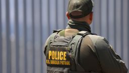 IMPERIAL BEACH, CALIFORNIA - AUGUST 17: A U.S. Customs and Border Protection (CBP) Border Patrol agent stands at Border Field State Park with the US-Mexico border wall in the background on August 17, 2025 in Imperial Beach, California. (Photo by Kevin Carter/Getty Images)