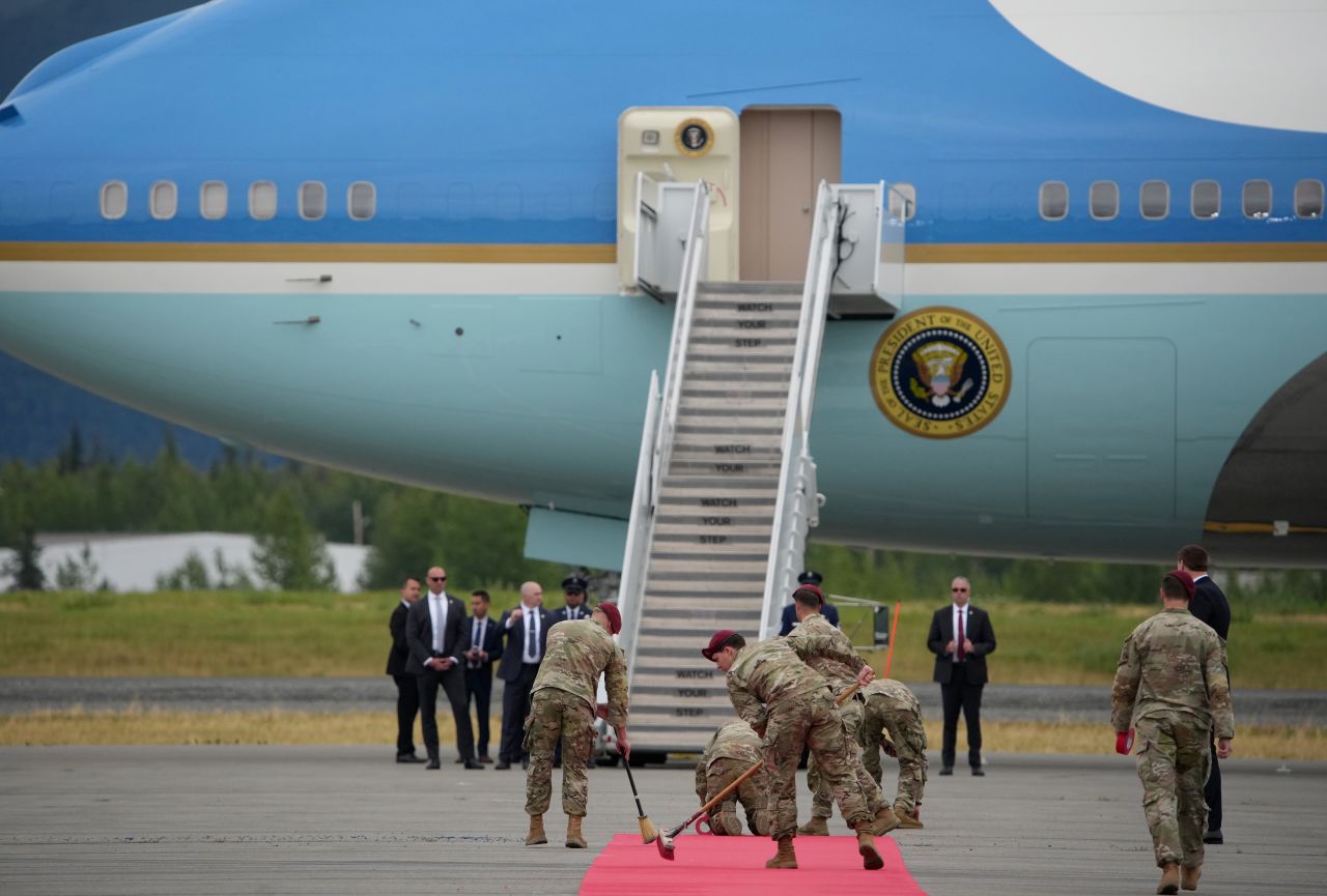 Personal militar barre la alfombra roja tendida frente al Air Force One para la llegada del presidente estadounidense Donald Trump a la Base Conjunta Elmendorf Richardson el 15 de agosto de 2025 en Anchorage, Alaska.