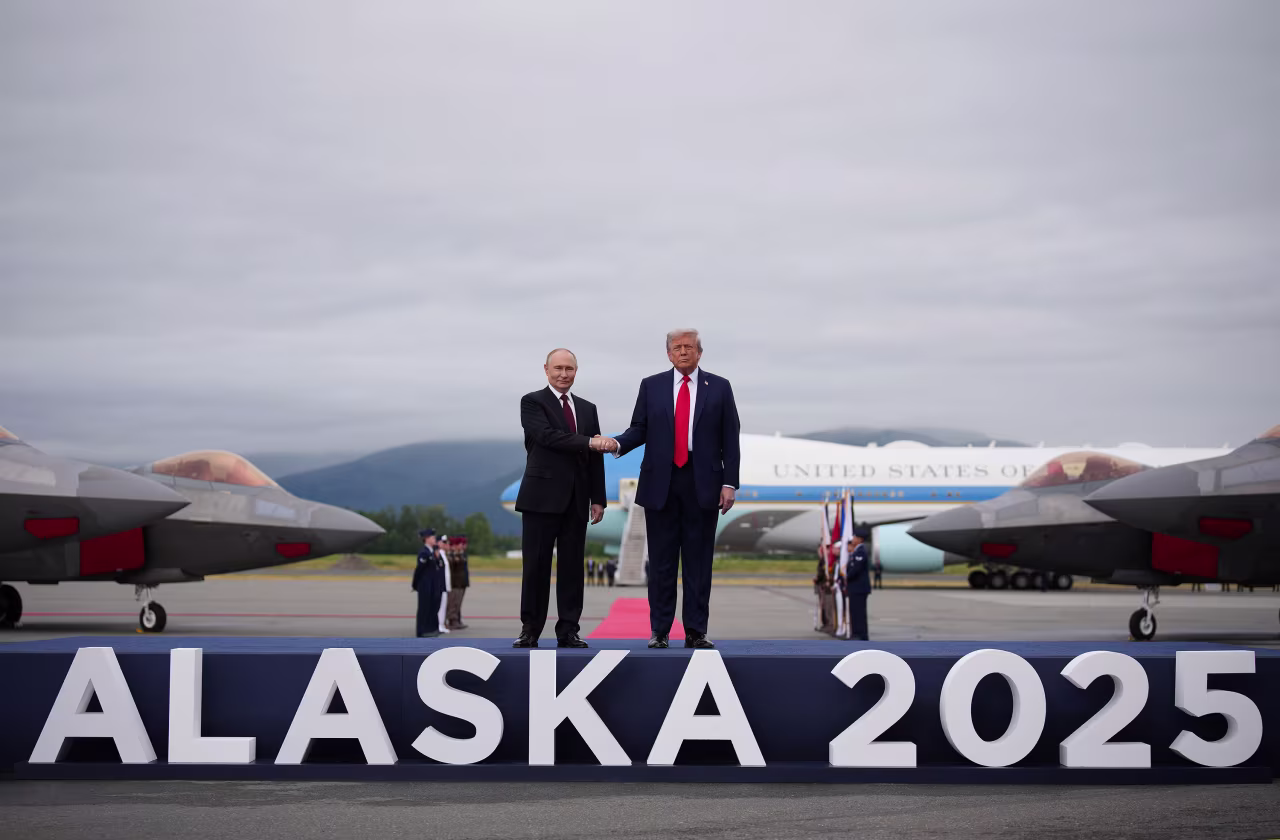 US President Donald Trump, right, greets Russian President Vladimir Putin at Joint Base Elmendorf-Richardson in Anchorage, Alaska, on Friday.