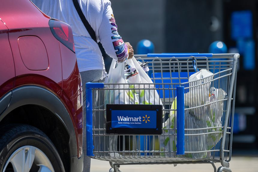 A shopper loads items into a vehicle outside a Walmart store in San Leandro, California, on August 19.
