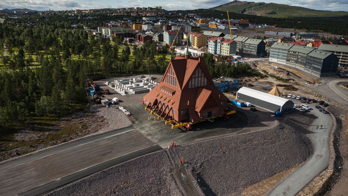 This aerial view shows the wooden Kiruna Church as it arrives at its final location, after a two-day relocation, from the old town to the new city center, in Kiruna, northern Sweden, on August 20, 2025. The church is being moved five kilometers to the new center of Kiruna due to the expansion of the iron ore mine operated by state-owned Swedish mining company LKAB. (Photo by Jonathan NACKSTRAND / AFP) (Photo by JONATHAN NACKSTRAND/AFP via Getty Images)          