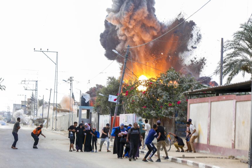 Palestinians rush to escape the area after Israeli warplanes' bomb strike on the tents where displaced Palestinians live in Deir al Balah, Gaza on Thursday.