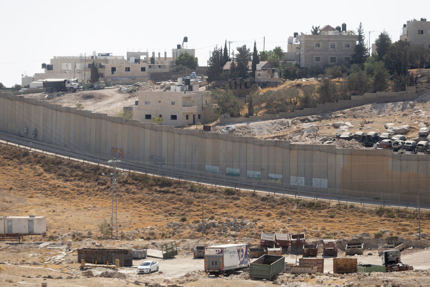 A view of the Palestinian town of Al Eizariya, a nearby separation wall and a nearby Palestinian town where the Israeli government plans to build thousands of homes as part of the E1 settlement project.