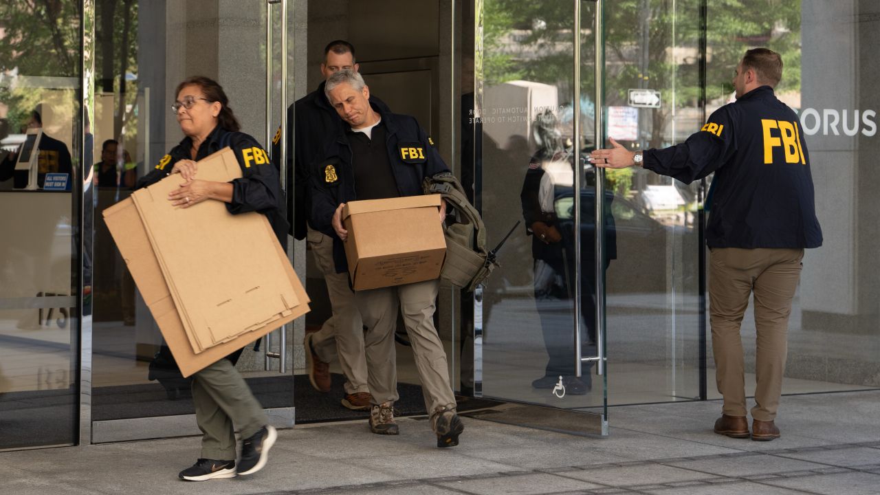 FBI agents leave the office of John Bolton, former national security adviser to President Trump, with several boxes and other materials on August 22, 2025 in Washington, DC.