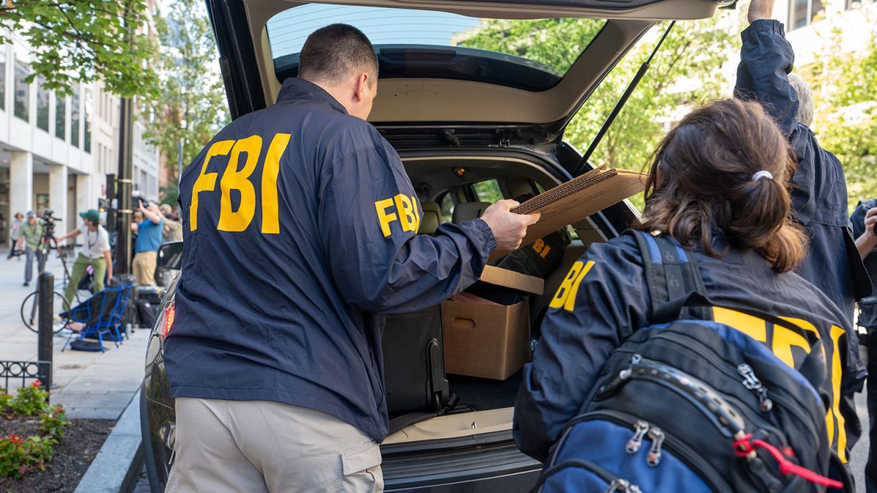 FBI agents leave the office of John Bolton, former national security adviser to President Trump, with several boxes and other materials on August 22, 2025 in Washington, DC.