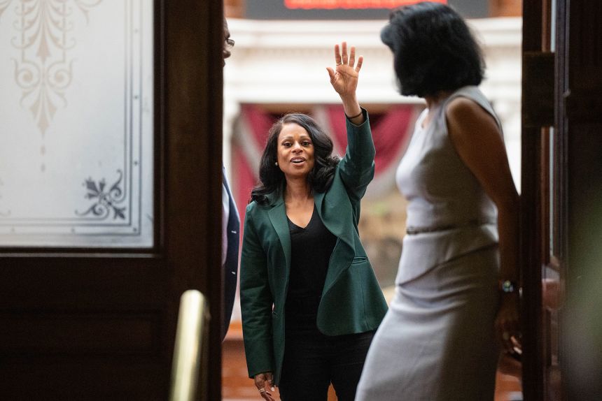 State Rep. Nicole Collier waves to supporters from inside the House Chamber at the Texas Capitol.