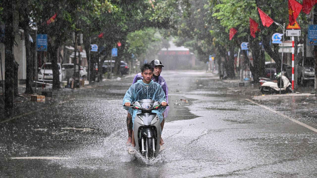 People drive through a flooded street in Nghe An province, north central Vietnam, where Kajiki made landfall on Monday.