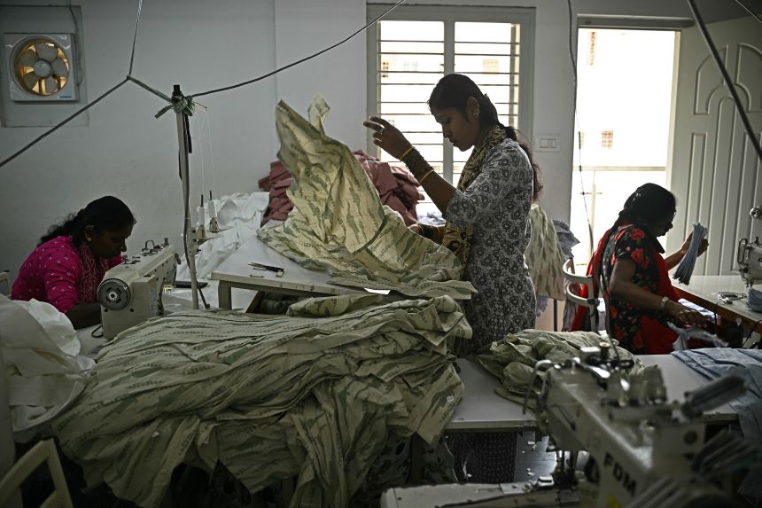 Garment workers sort clothing material for dresses at an apparel manufacturing unit in Bengaluru, India, on August 25, 2025. US President Donald Trump has threatened to double import duties on India from 25% to 50% by August 27 to punish New Delhi for buying oil from Russia, saying the purchases help Moscow fund its invasion of Ukraine.