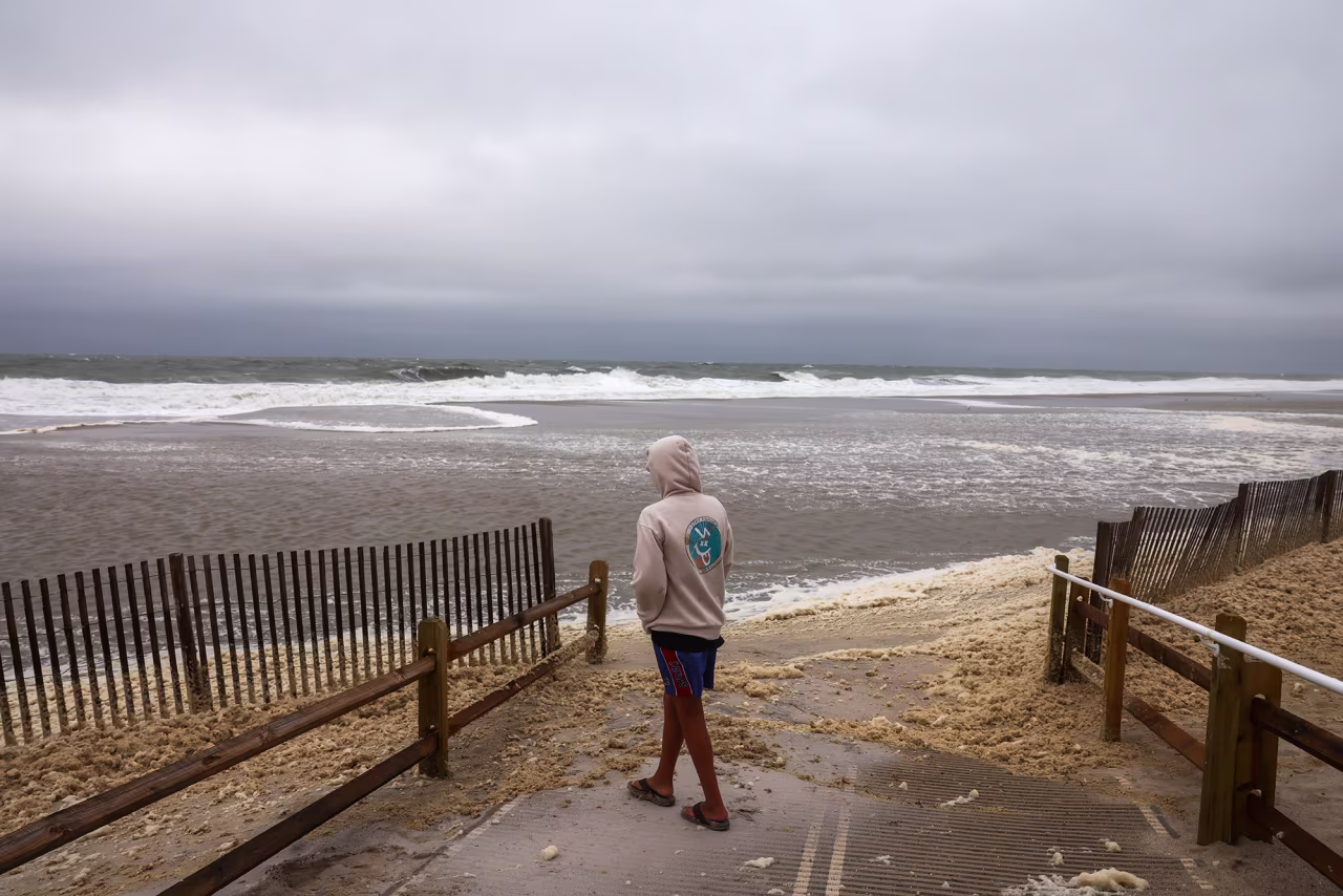 A person walks near the beach as large waves from Hurricane Erin keep swimmers away on  in Seaside Heights, New Jersey, on Thursday.