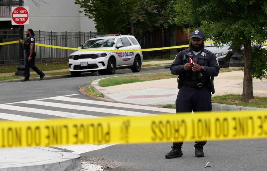 An officer with the Metropolitan Police Department collects evidence at a shooting on H Street Northeast in Washington, DC, on August 21, 2025.