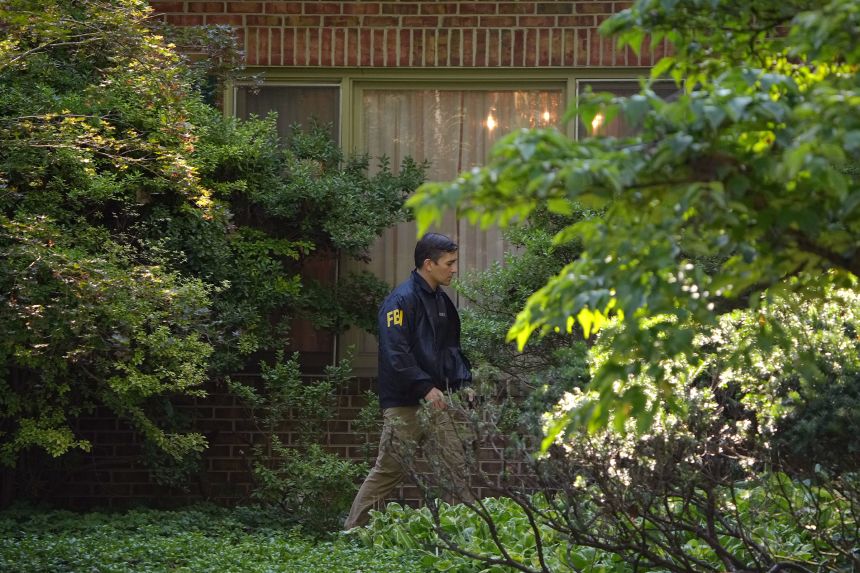 An FBI agent work outside the home of John Bolton in Bethesda, Maryland, on Friday