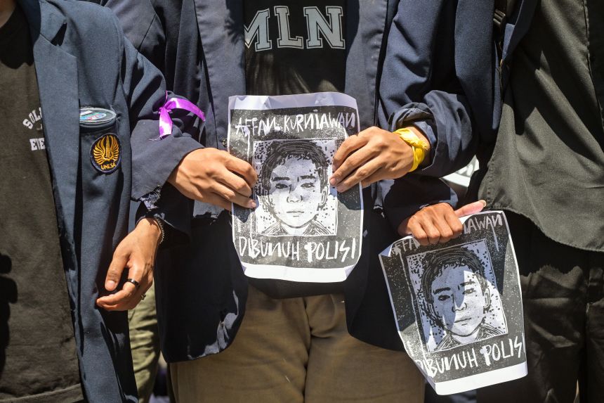 The protesters hold a portrait of Awan Kruniawan, a ride-share motorcyclist who was attacked and killed by a police armored vehicle on August 28, 2025.