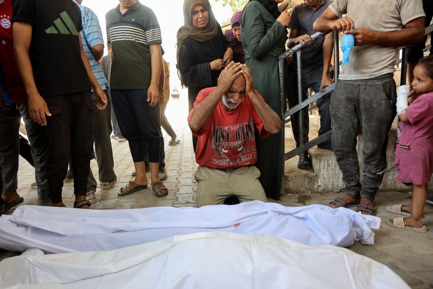 Palestinians lament the tattered bodies of a family member killed in an Israeli strike on Saturday at a makeshift bakery in a tent on Al Nasr Street in Gaza city.
