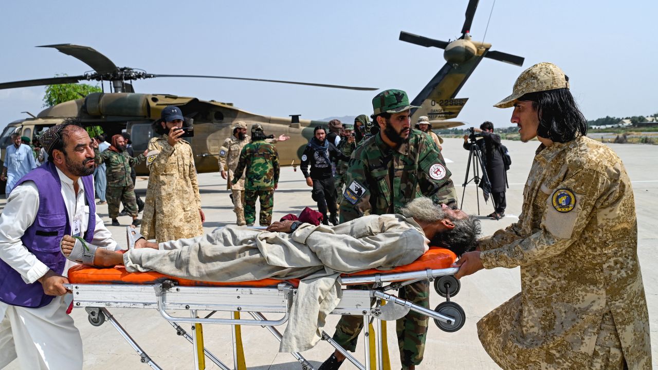 Afghan volunteers and Taliban security personnel carry an earthquake victim evacuated by a military helicopter from the Nurgal district of Kunar province, after his arrival for medical assistance in Jalalabad on September 1, 2025. A massive rescue operation was underway in Afghanistan on September 1, after a strong earthquake and multiple aftershocks flattened homes in a remote, mountainous region, killing more than 800 people, the Taliban authorities said. (Photo by Wakil KOHSAR / AFP) (Photo by WAKIL KOHSAR/AFP via Getty Images)