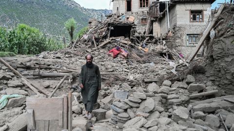 An man Afghan walks past a damaged house following earthquakes in the Mazar Dara village of Nurgal, a district of the Kunar Province, in Eastern Afghanistan, on September 1, 2025.