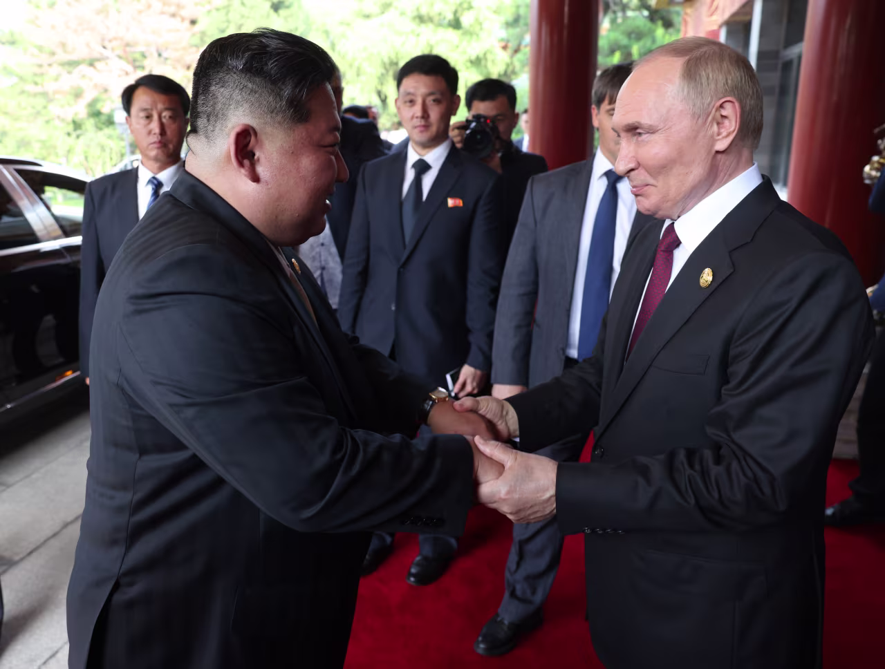 Vladimir Putin greets Kim Jong Un after their bilateral meeting