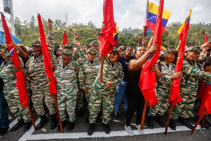 Members of the Bolivarian Militia and supporters of Venezuelan president Nicolas Maduro participate in a flag-raising ceremony for the Community Squads for the Comprehensive Defense of the Nation, in Caracas, Venezuela on September 3.