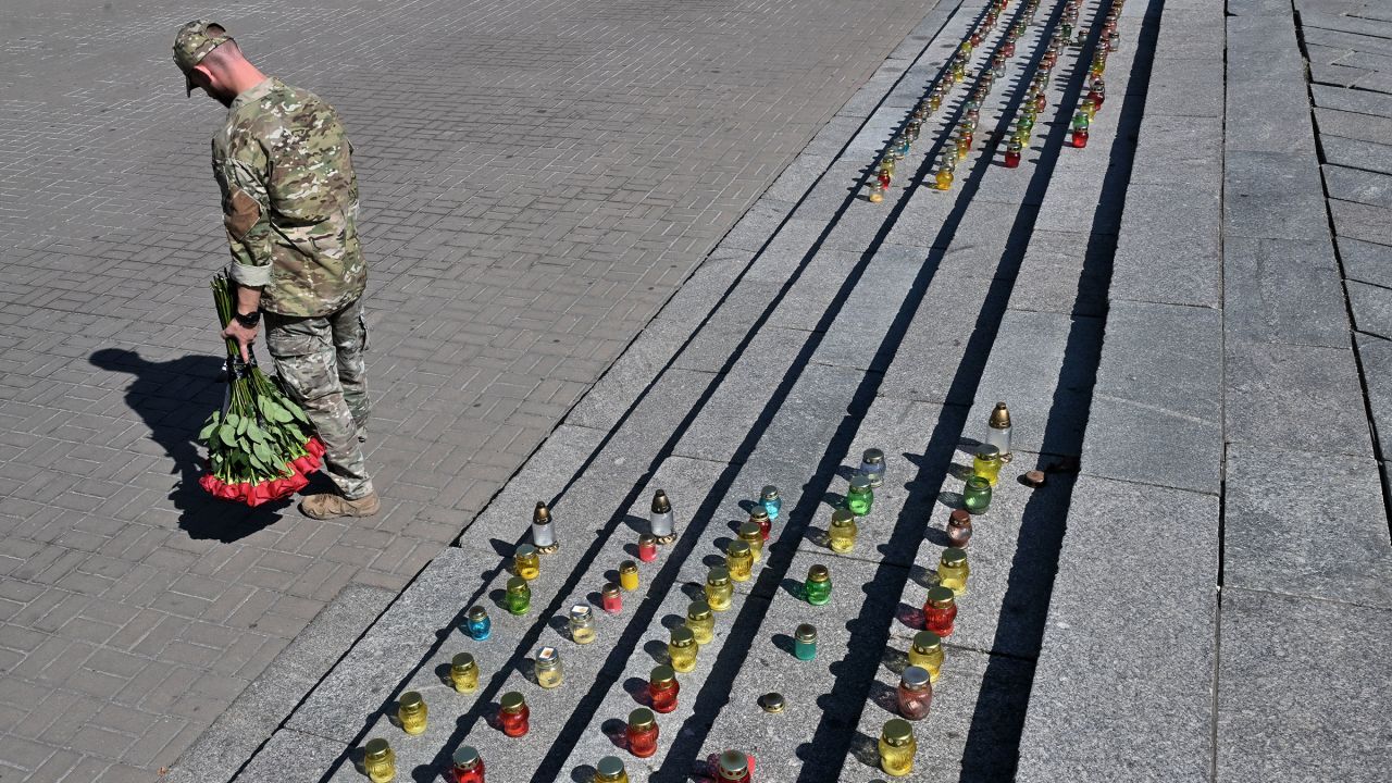A Ukrainian serviceman holds flowers as he mourns at a makeshift memorial for fallen Ukrainian and foreign soldiers at Independence Square in Kyiv, Ukraine, on September 5, 2025.