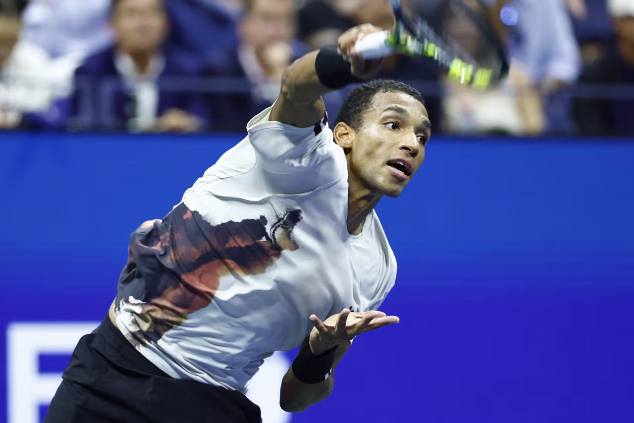 Félix Auger-Aliassime serves to Jannik Sinner during Friday's match.