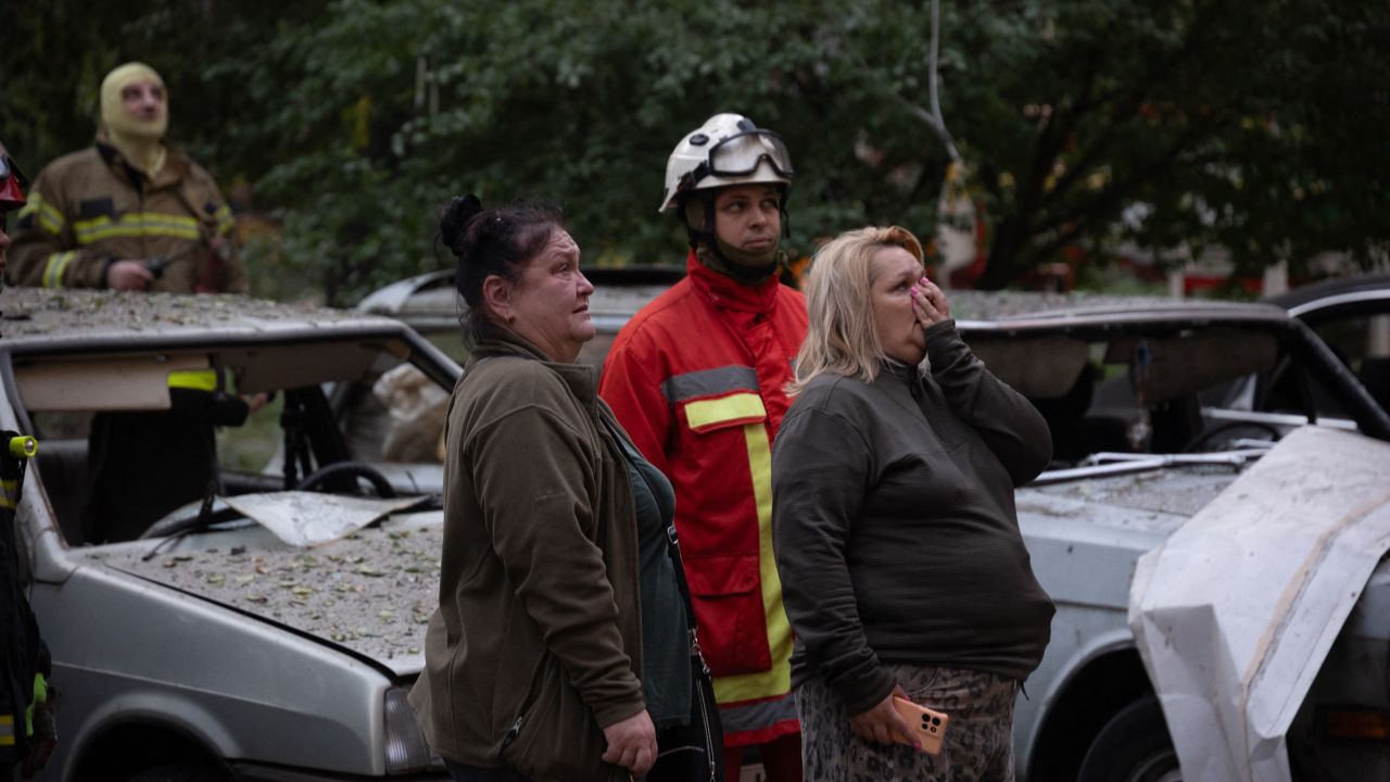 Local residents stand next to a damaged car in front of a heavily damaged residential building following Russian drone and missile strikes in Kyiv on September 7, 2025, amid the Russian invasion of Ukraine. Russia fired its biggest-ever aerial barrage at Ukraine early on September 7, setting the seat of the Ukrainian government in Kyiv ablaze, authorities said. (Photo by Oleksandr Magula / AFP) (Photo by OLEKSANDR MAGULA/AFP via Getty Images)          