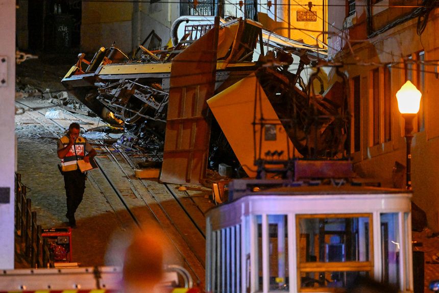 A police officer walks past the remains of the wrecked Gloria funicular derail site in Lisbon, Portugal, on September 3, 2025.