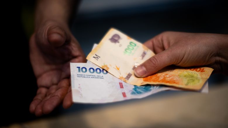 A customer pays for food with Argentine peso banknotes in the financial district of Buenos Aires, Argentina, on September 8, 2025.