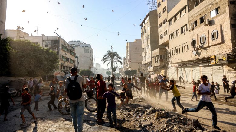 People watch as leaflets dropped by the Israeli military, urging evacuation south to al-Mawasi, land in Gaza City on September 9, 2025. The Israeli military said on Tuesday that it will act with "greater force" in Gaza City and warned residents to flee, in a statement posted on X. Israel has been intensifying its bombardment of the city in preparation for an operation to take control of it, despite repeated entreaties from Western nations and aid agencies to stop.