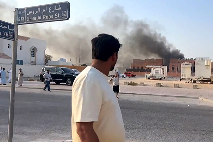 This frame grab taken from an AFPTV footage shows a man looking at smoke billowing after explosions in Doha's capital Qatar on September 9, 2025. An Israeli military official told AFP that the military had carried out air strikes in an operation targeting senior leaders of Palestinian militant group Hamas.
