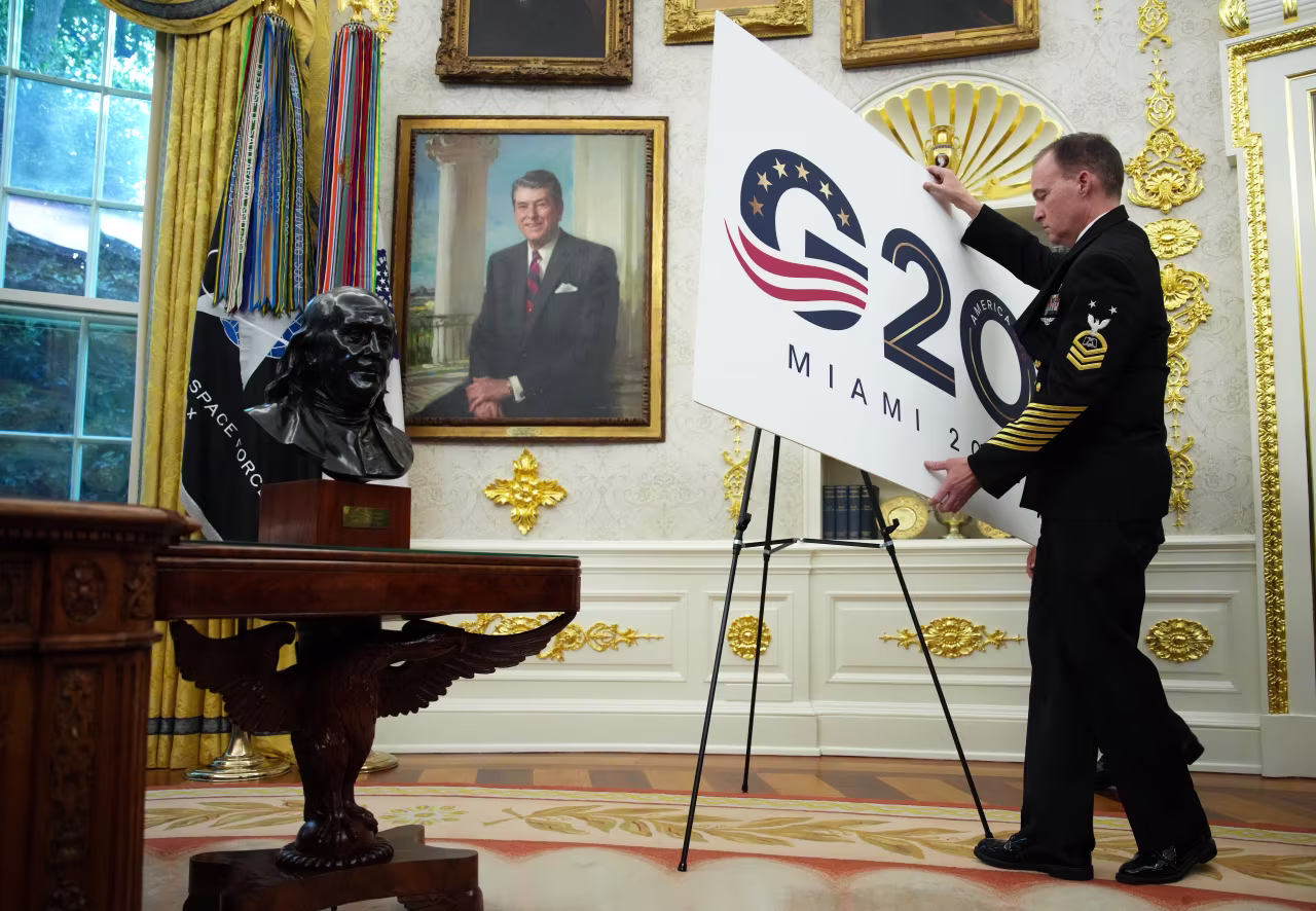 A staff member arranges a display as President Donald Trump announces plans to host the 2026 G20 summit in Miami, Florida.