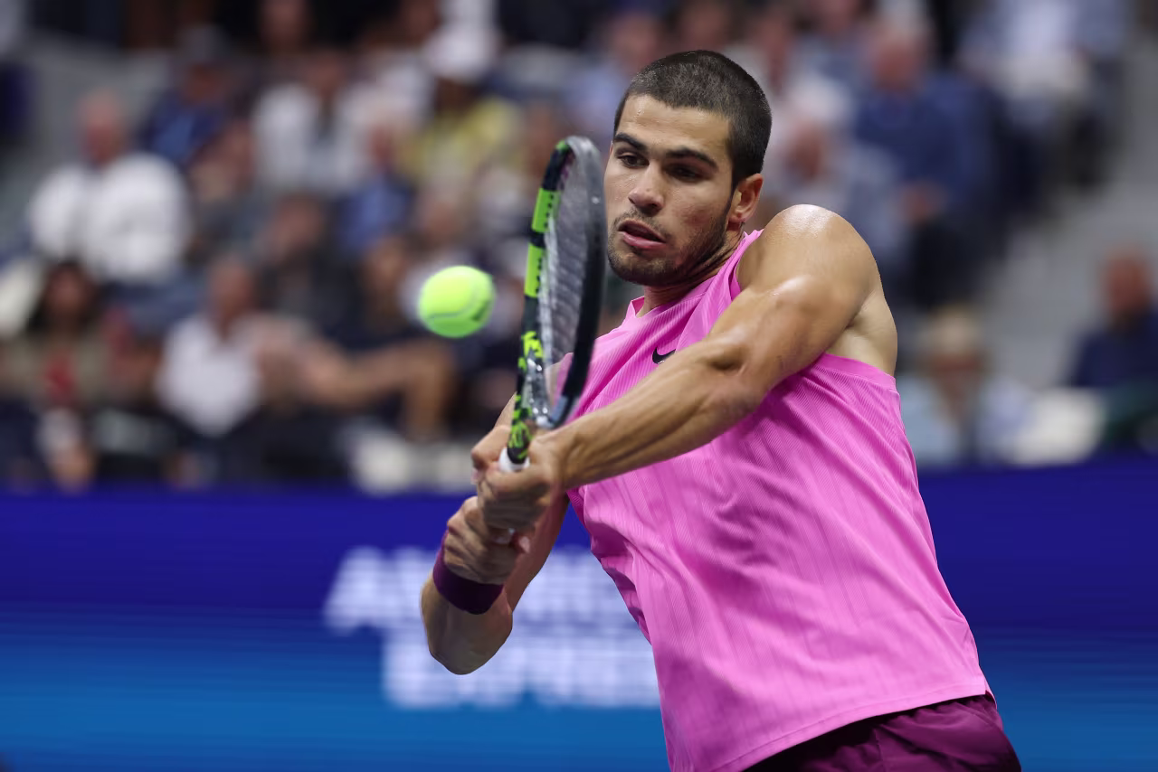 Carlos Alcaraz hits a backhand in the fourth set.