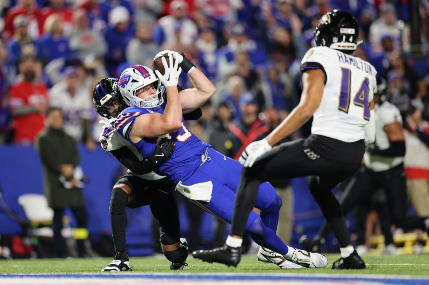 Jackson Hawes of the Buffalo Bills catches a pass with pressure from Nate Wiggins of the Baltimore Ravens during the fourth quarter.