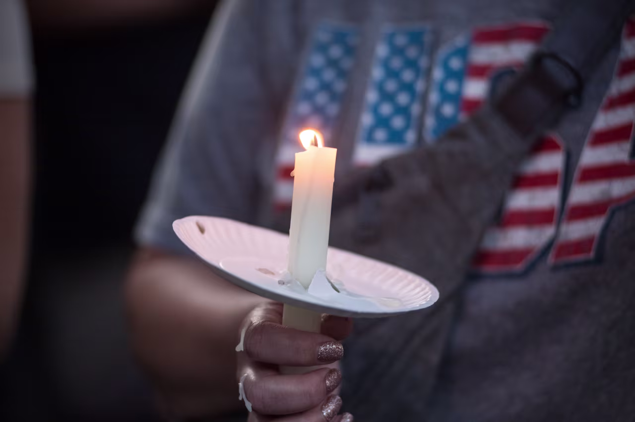 Residents of Lemont, Illinois, come together in a serene park setting to pay tribute to Charlie Kirk during a vigil. Turning Point USA headquarters was established in Lemont in 2012.