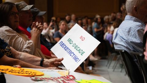 Demonstrators hold signs during a rally opposing redistricting at the Indiana Statehouse in Indianapolis, Indiana, on September 18.