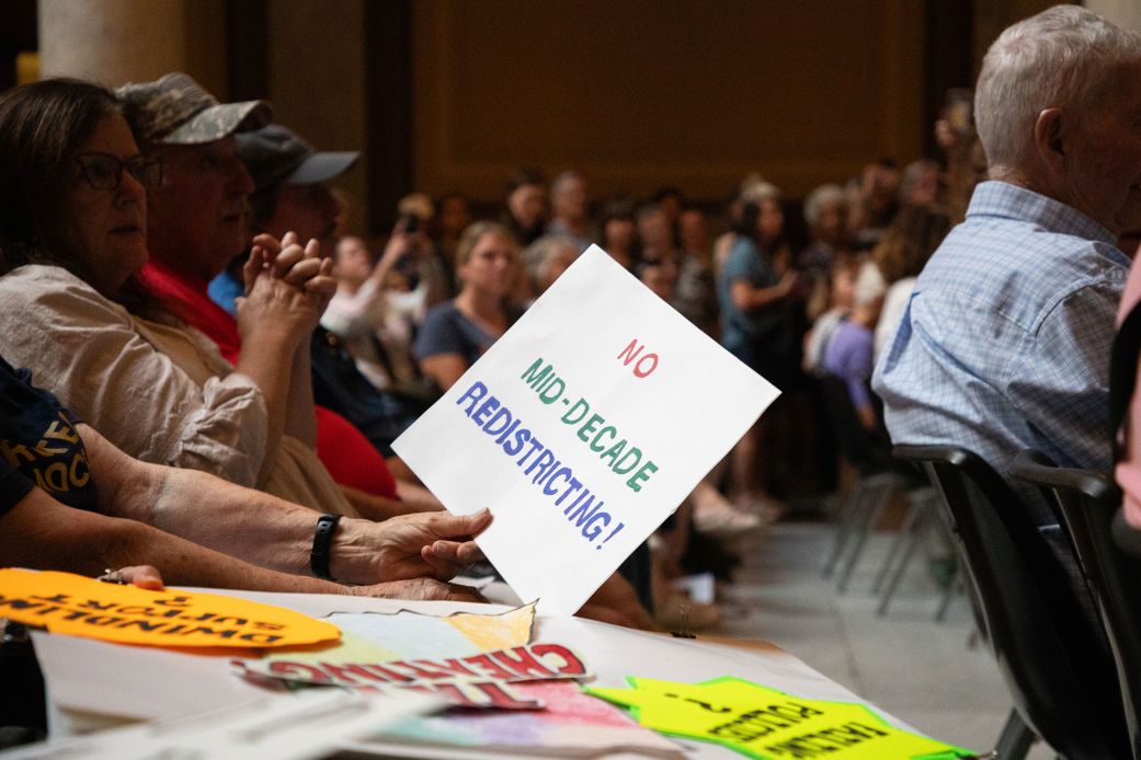 Demonstrators hold signs during a rally opposing redistricting at the Indiana Statehouse in Indianapolis, Indiana, on September 18.