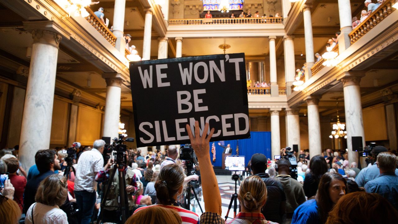 A demonstrator holds a sign during a rally against redistricting at the Indiana Statehouse in Indianapolis, Indiana, on September 18, 2025.
