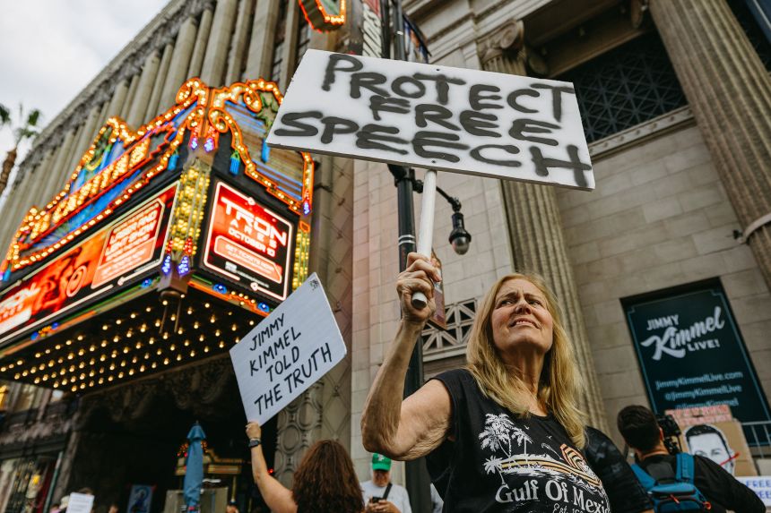 A demonstrator holds a sign reading Protect Free Speech outside the El Capitan Theatre in Hollywood, California, on Thursday.