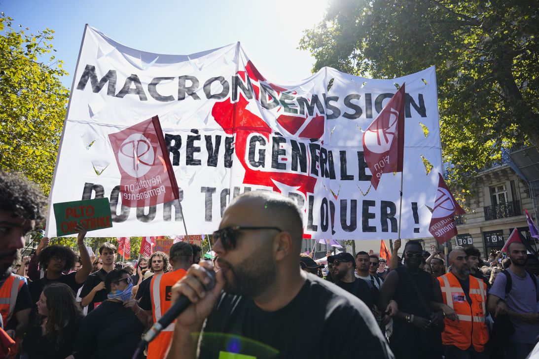 Demonstrators carrying a flag that calls on Macron to resign, in Paris on September 18, 2025.