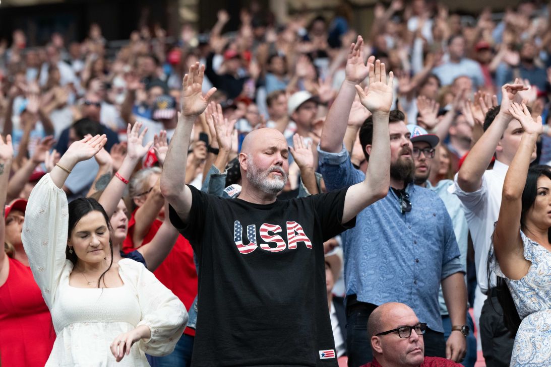 Charlie Kirk supporters are seen raising their hands while a Christian singer leads the crowd during the memorial service for Charlie Kirk at State Farm Stadium in Glendale, Arizona, on Sunday.