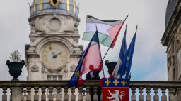 An employee places the Palestinian flag along side the French Flag, the flag of Lyon, and the European Union flag, over the entrance of the Lyon City Hall, in eastern France, on the day France plans the recognition of a Palestinian State at the United Nations on September 22. Over 50 town halls in France were flying the Palestinian flag on September 22, 2025, in defiance of an interior ministry warning not to do so ahead of the recognition of a Palestinian state by French President Emmanuel Macron.