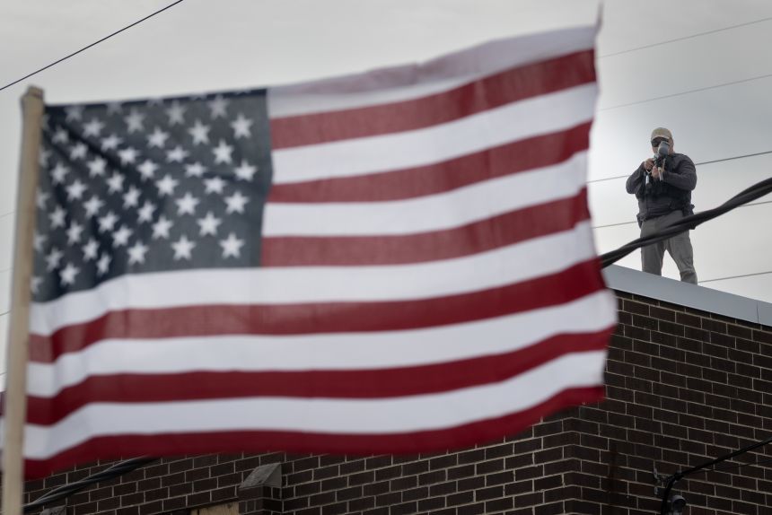 A federal law enforcement agent aims a pepper ball gun at demonstrators protesting outside of an immigration processing center in Boradview, Illinois, on September 19.