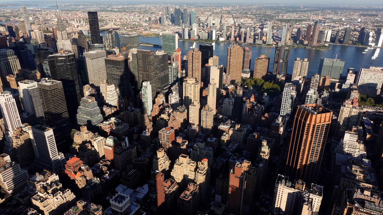 The Empire State Building casts a shadow on buildings on the east side of midtown Manhattan as seen from the 86th floor observation deck as the sun sets on September 18, 2025, in New York City.