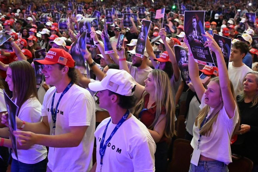 Attendees hold posters with a photo Charlie Kirk during an 