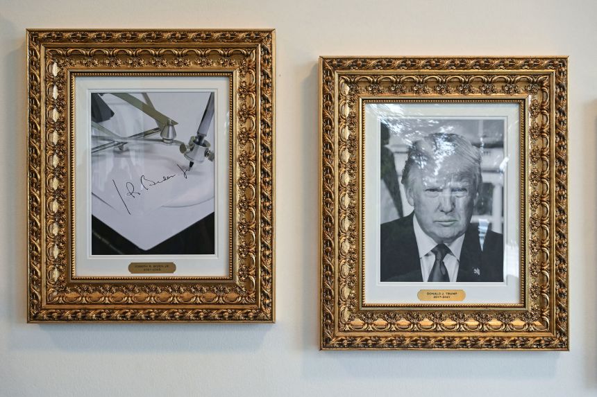 A framed photo of President Donald Trump hangs next to a picture of an "autopen," intended to represent former President Joe Biden, which Trump had placed  on the wall of the colonnade near the Rose Garden of the White House in Washington, DC on September 25.