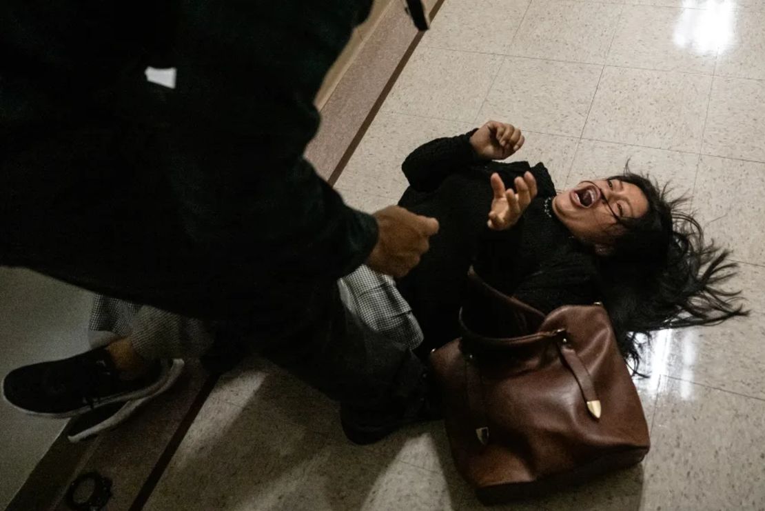 Un agente federal empuja a una mujer al suelo durante un enfrentamiento en un tribunal de inmigración el jueves en la ciudad de Nueva York.
